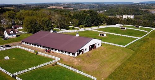 Aerial view of the white barn and fenced paddocks at Thunder Ridge Farms in Warren County, NJ